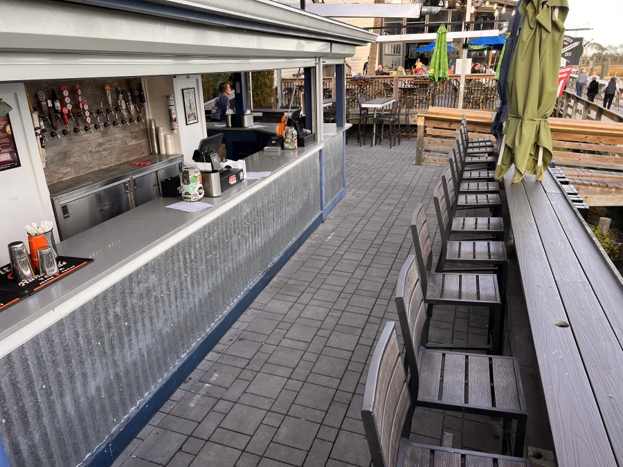 The MarshWalk boardwalk early in the day, bar stools stacked and the decks still empty